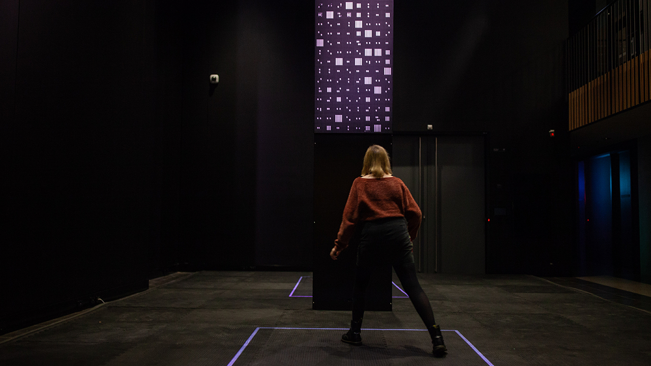 Woman dancing to the right watching icons on the screen change.