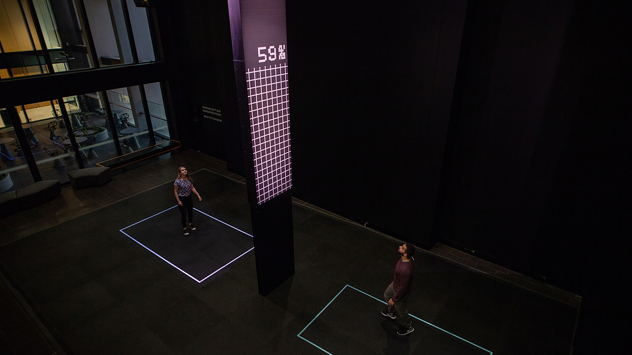 Man and woman standing in coloured boxes, screen reads 59 percent.