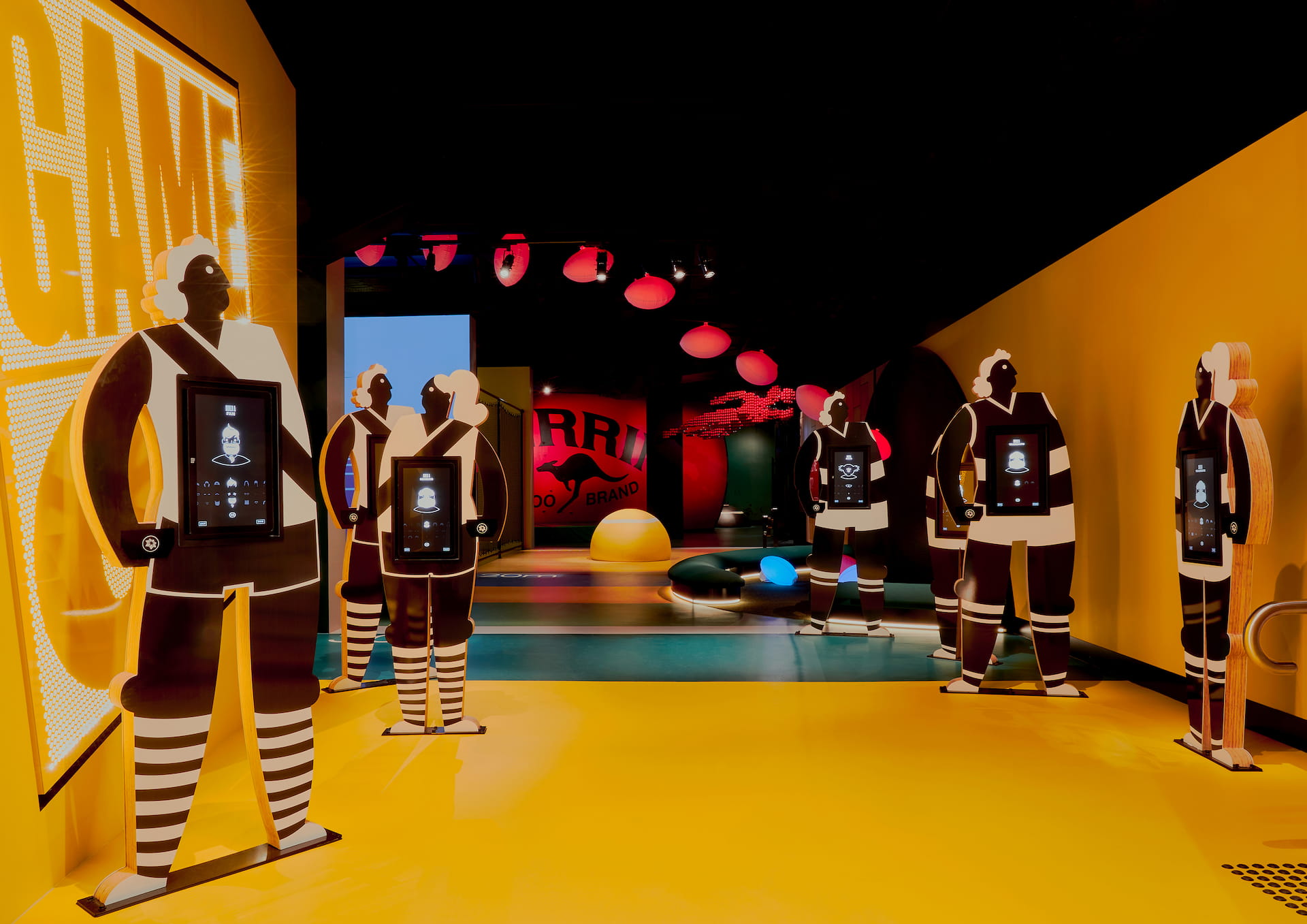 Interactive sports exhibition Wooden cutouts of men and women with touch-screens on their chests.