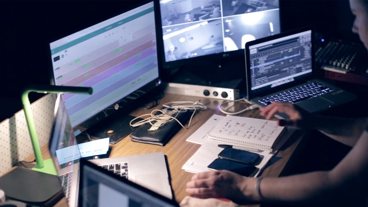 Ghosts film set Woman editing film across multiple screens and laptops.