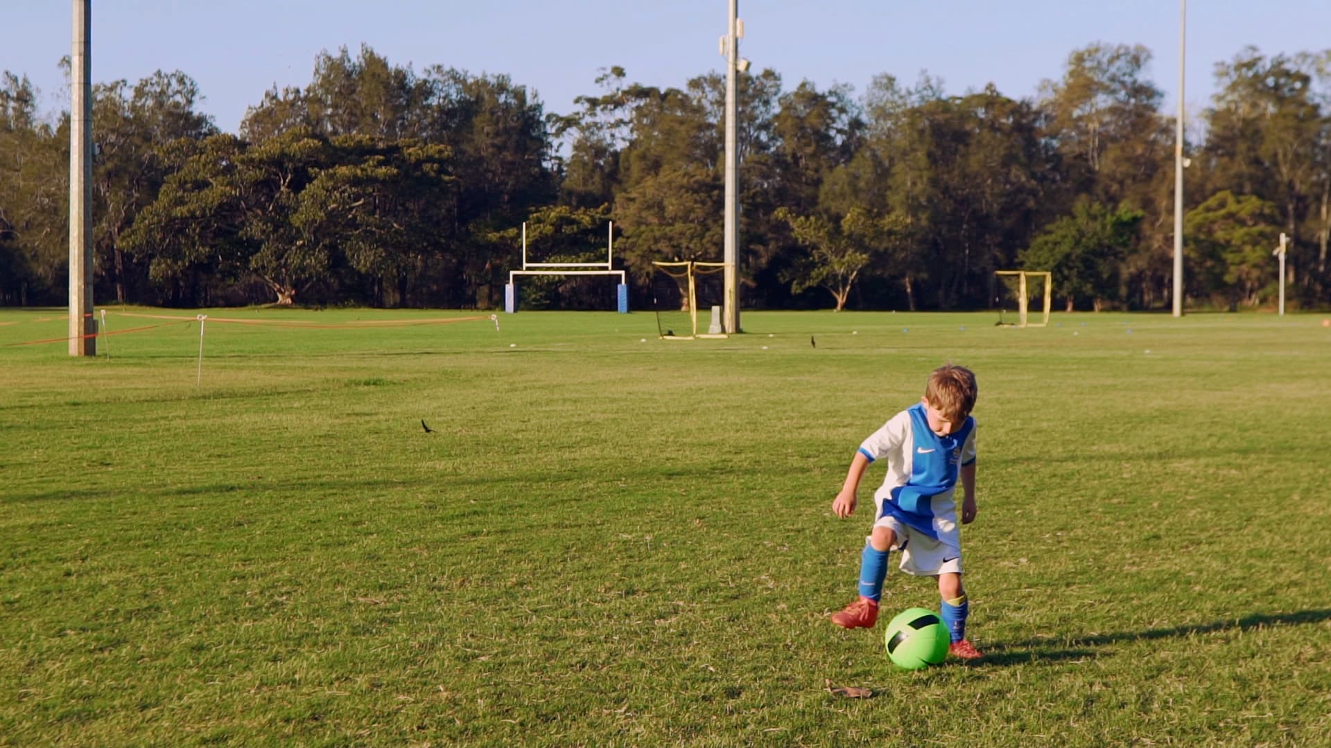 Soccer photography Boy in uniform dribbling green soccer ball.
