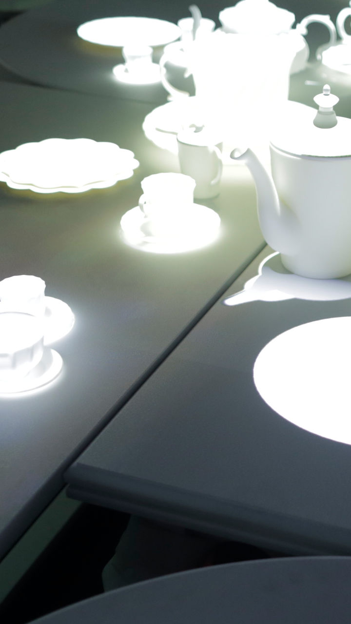 Projection-mapped mad hatters tea party Close-up of tea cups and saucers.
