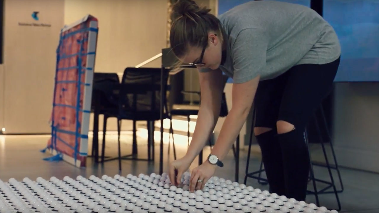 Pixel wall installation Woman aligning lightbulbs on pixel interface.