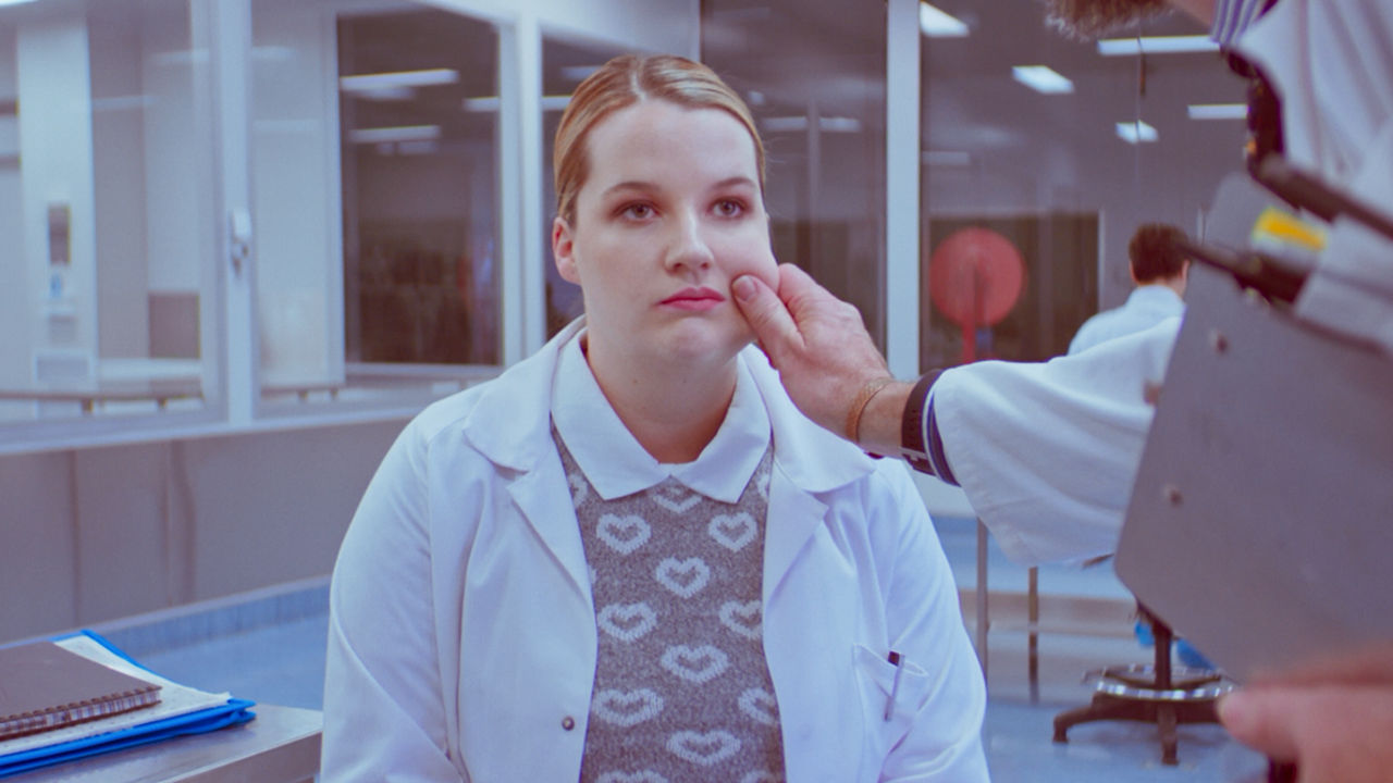 Acting on set Man's hand pulling woman's cheek.