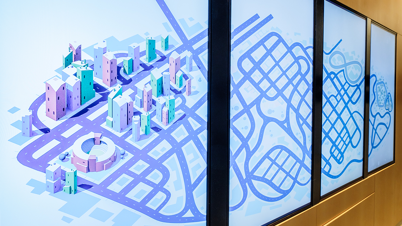 Data visualisation screens Medium full shot of the Road to Zero foyer activation, four vertical screens displaying a stylised cityscape.