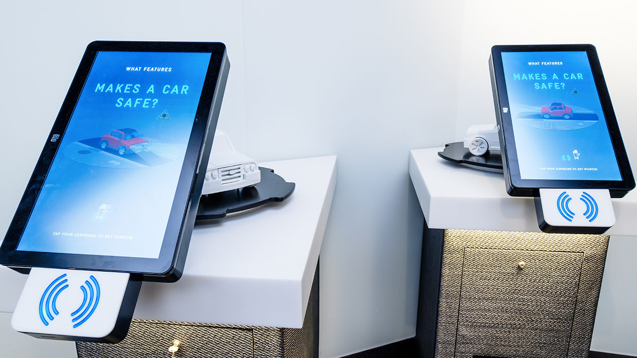 Two large touchscreens with NFC reader attached asking what features makes a car safe?