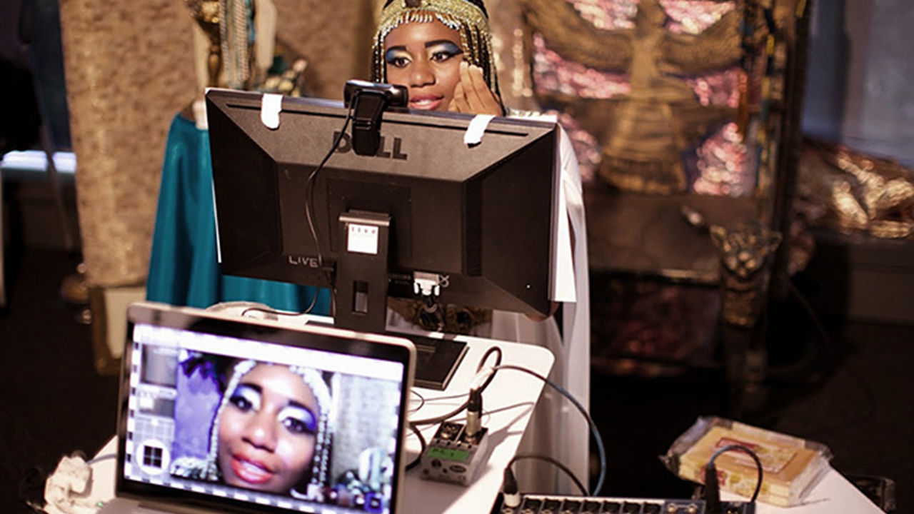 Actors on film set Shakespeare actress on a webcam, video footage played through a laptop in the foreground.