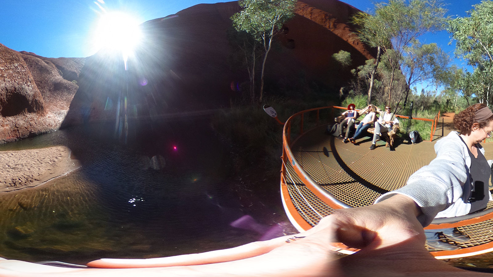 Uluru photoshoot Woman taking selfie over water.