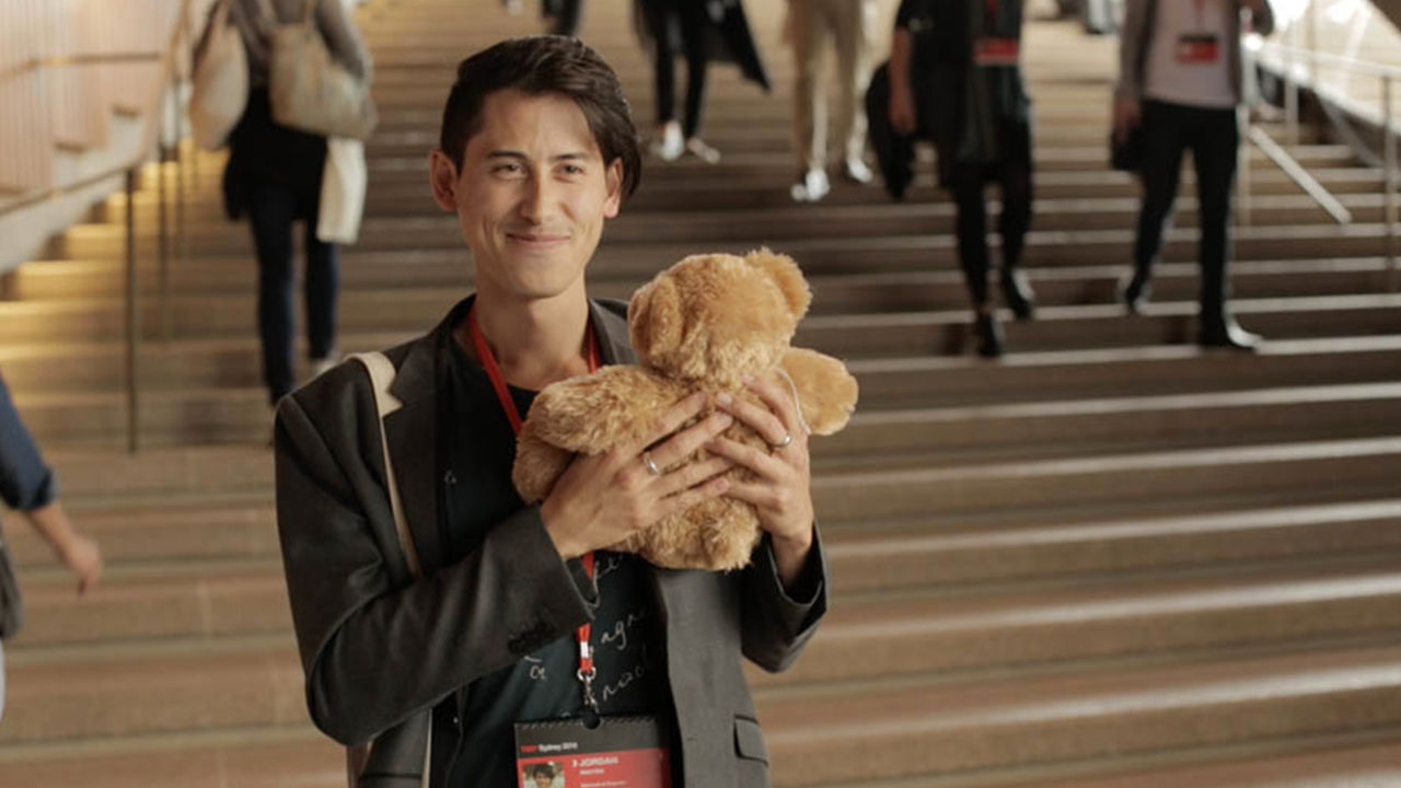 Proximity based storytelling Man holding a TeddyX bear in the Opera House.