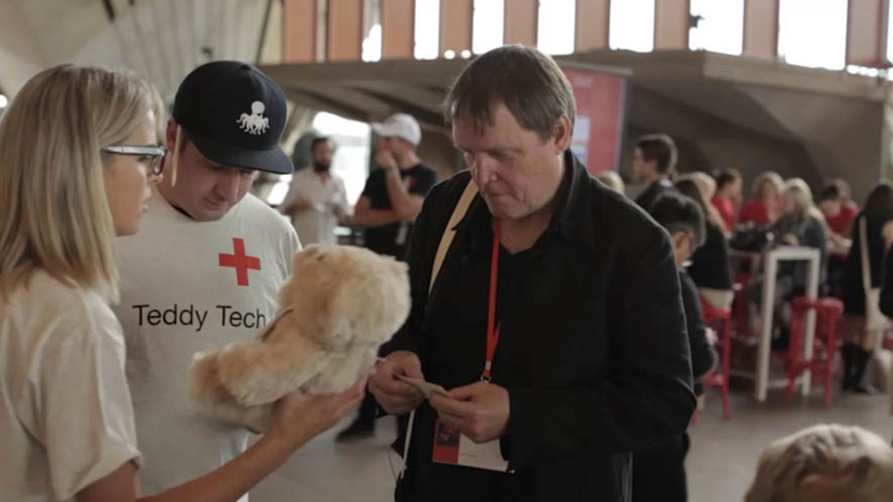 Interactive teddy experiment Teddy technicians assessing a TeddyX bear for a visitor.