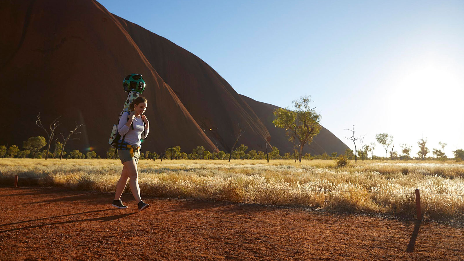 Photoshoot in Uluru Woman on dirt track with Uluru in background.
