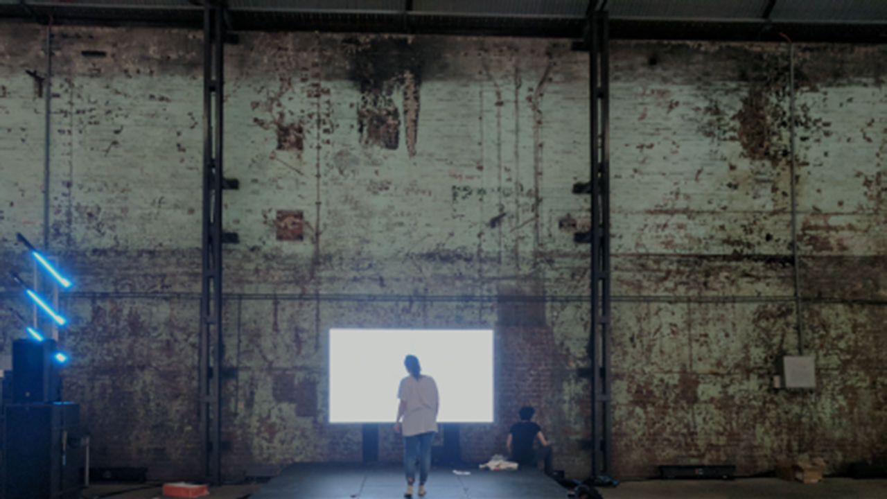 Wings activation installation Man with hands raised, screens show his silhouette with wings.